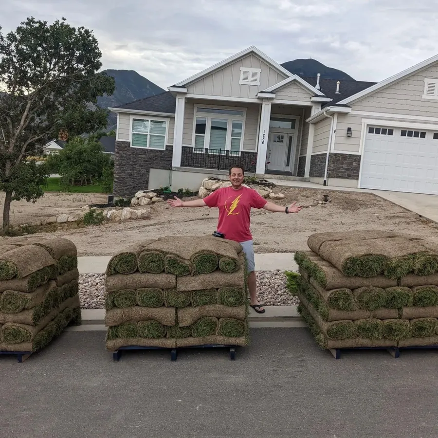 TOR Turf owner standing between three pallets of sod delivered to a Utah home